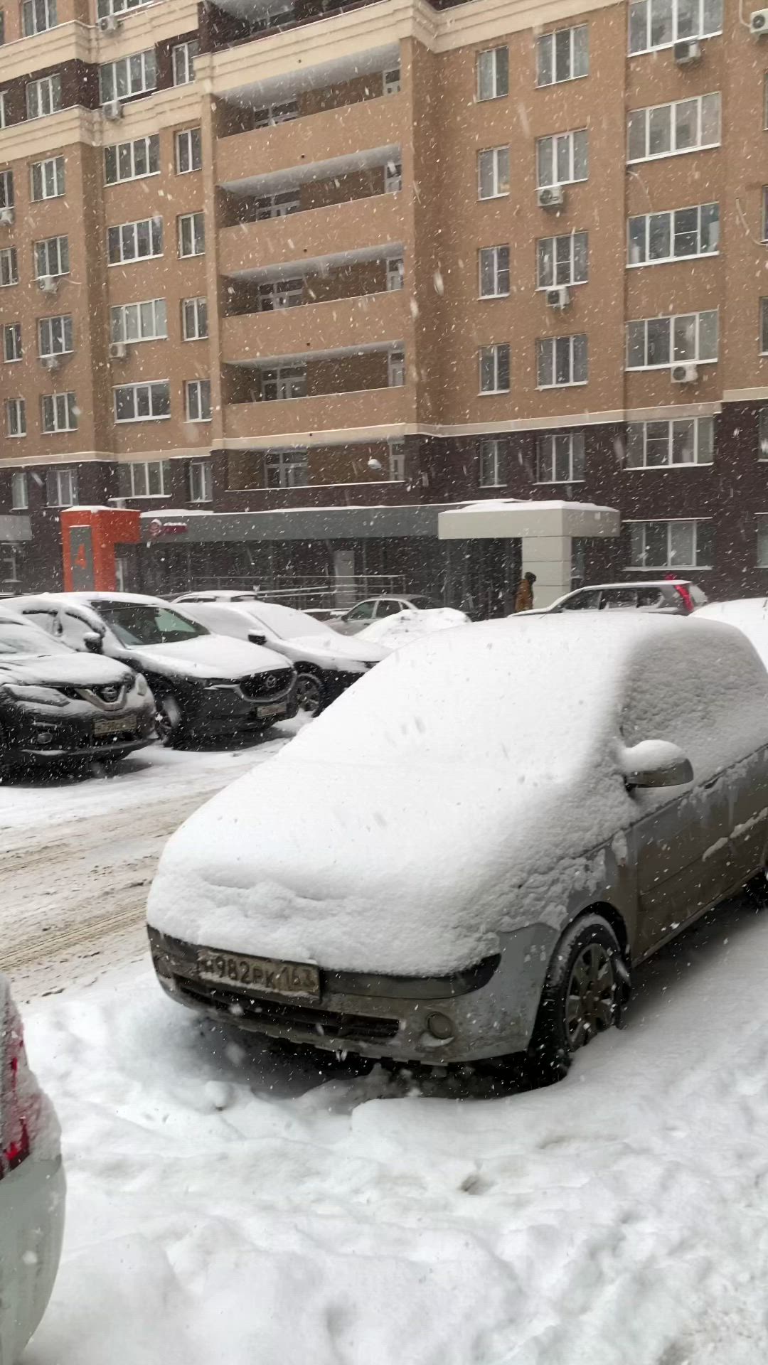 This may contain: cars are covered in snow on a city street