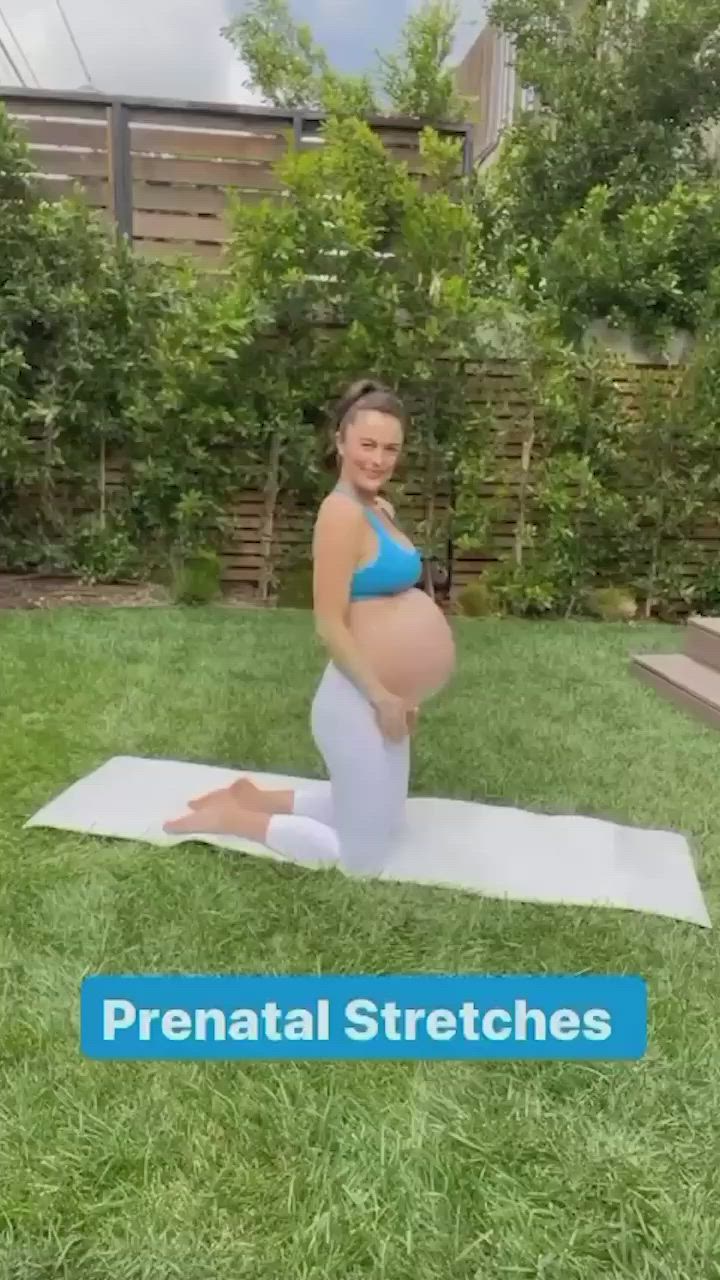 This may contain: the pregnant woman is doing yoga in her backyard