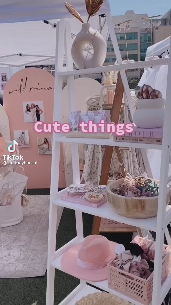 This may contain: a white shelf with hats and other items on it that says cute things in pink