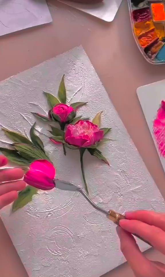 This may contain: someone is painting flowers on a piece of paper