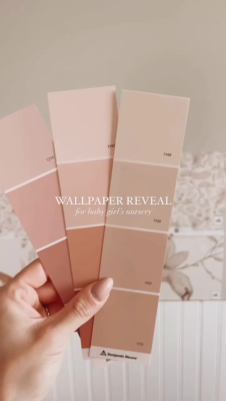 This may contain: a hand holding three swatches of wallpaper in various shades of pink and beige