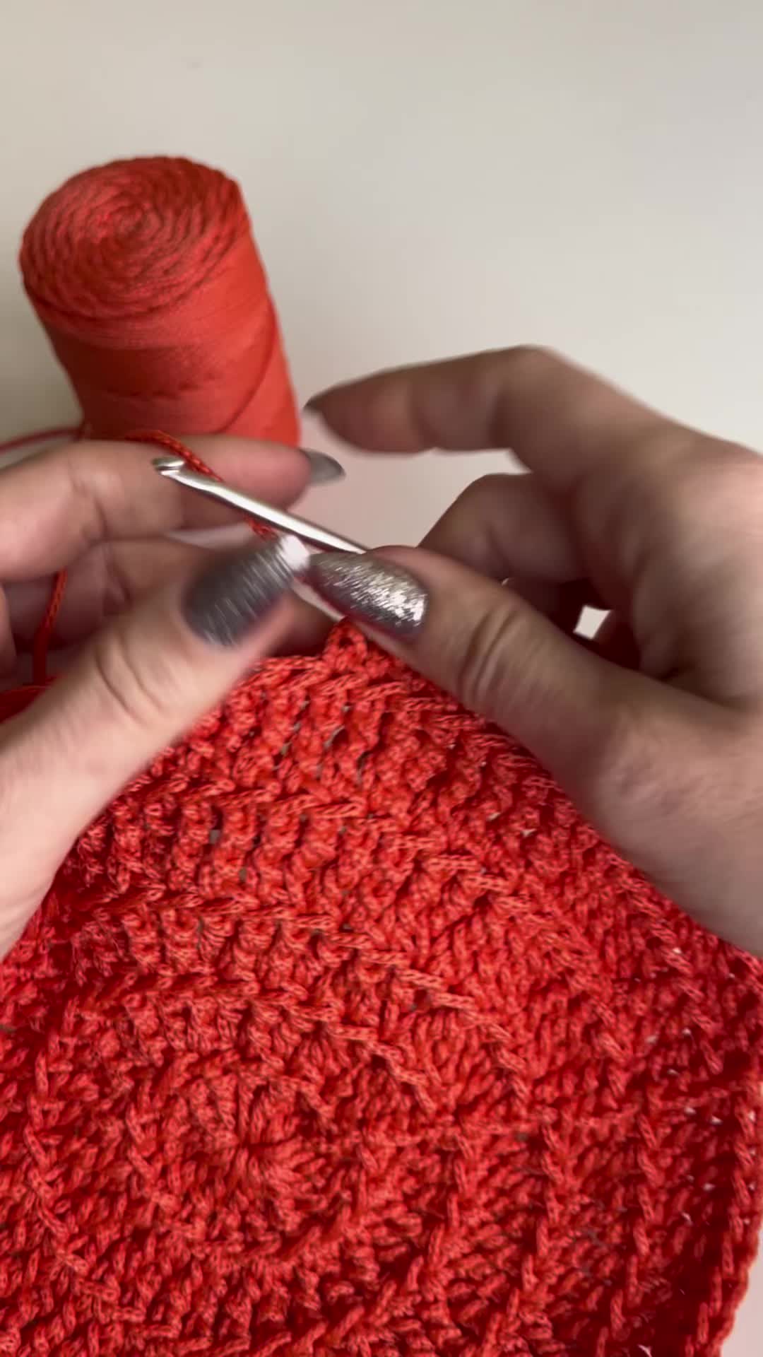 This may contain: someone is crocheting an orange flower with yarn