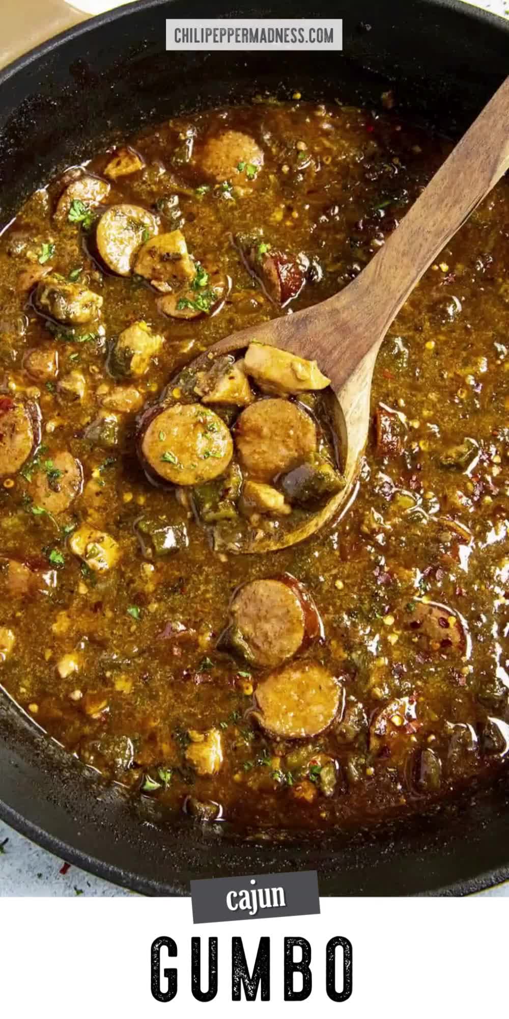 This may contain: a white bowl filled with gumbo and meat on top of a wooden cutting board