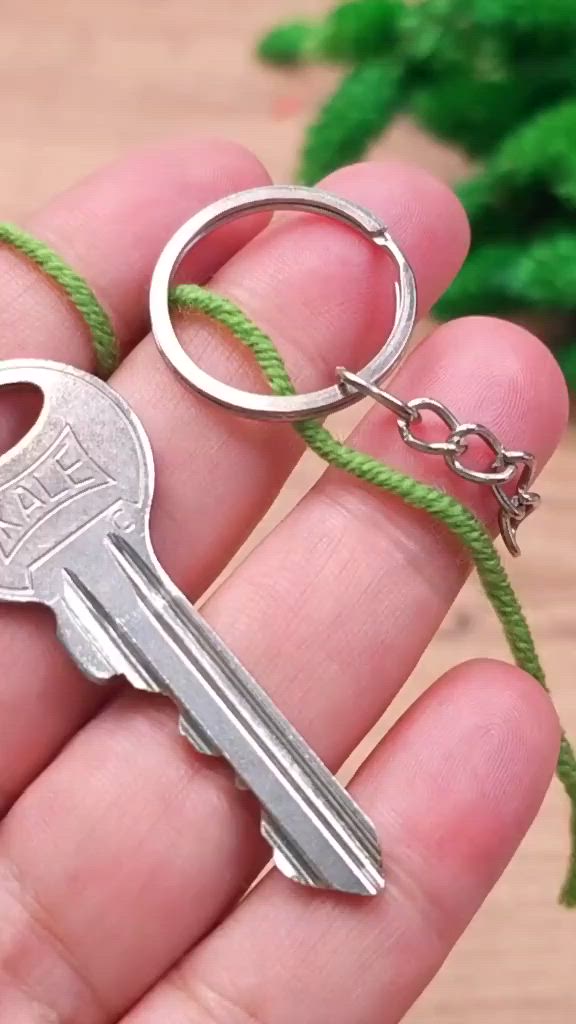 This may contain: a person is holding a key chain with two keys attached to it, while the other one has a green cord