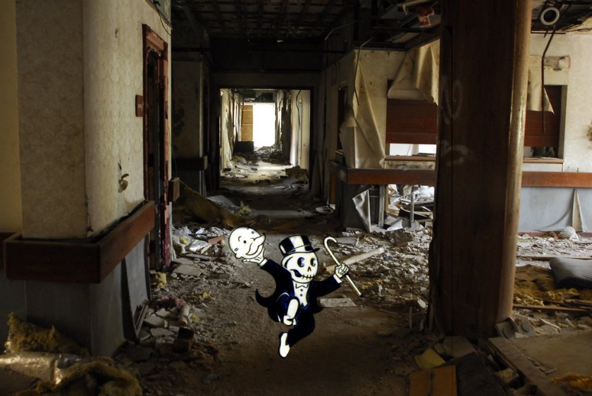 An abandoned, ruined hospital wing; in the foreground, a dancing Uncle Pennybags figure from the Monopoly game, he has removed his face, revealing a skull.