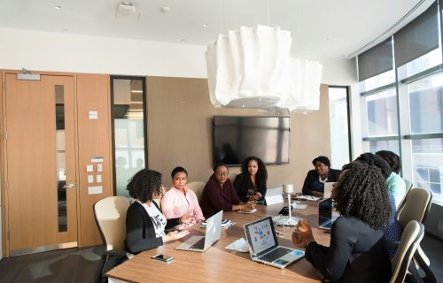 Sched Vs. Cvent Comparison: People At Table With Laptops Having A Discussion