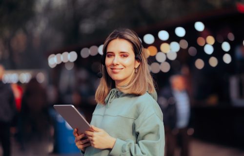 Music Festival Organizer Wearing A Headset And Holding An Ipad For A Sched Vs. Hubilo Comparison