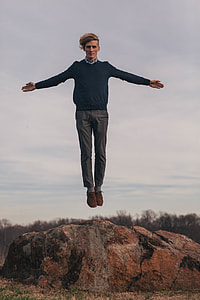 jump shot photography man in long sleeves shirt and gray pants