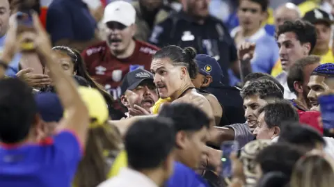 Darwin Núñez standing in a crowd confronting Colombia fans