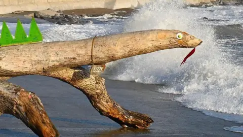 Lizzy the lizard, actually a piece of driftwood, washed up on a beach in Porthcawl