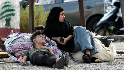 A boy and girl resting ont he side of the road