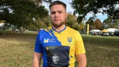 A man in a blue and yellow running top looks at the camera