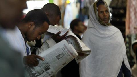 A businesman and customers read a newspaper 14 May 2005 in the old Mercato (market) in Addis Ababa, Ethiopia.