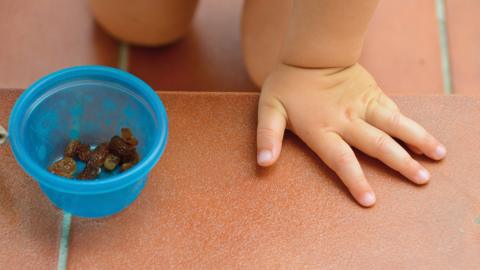 Child with bowl of raisins