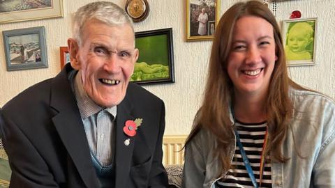 Richard Dodd, complete with poppy, and Laura Titterington in his lounge