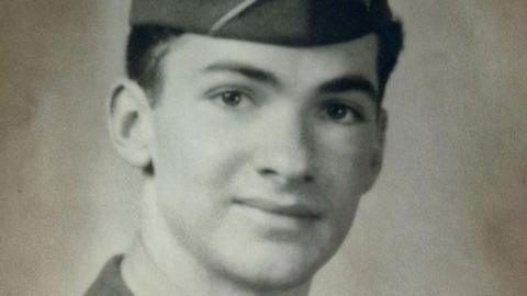 A black and white image of private first class Earl G Thurman of the US 82nd Airborne during World War Two. He is wearing a garrison cap. 