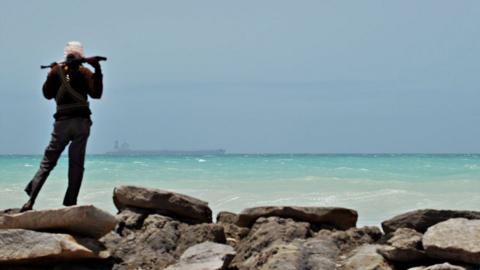 A pirate stands with his high calibre weapon near the central Somalia town of Galkayo on August 18, 2010