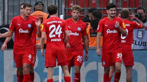 Jann-Fiete Arp (number 20) celebrates scoring with his Holstein Kiel team-mates