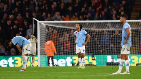 Nathan Ake stands with his hands on his hips