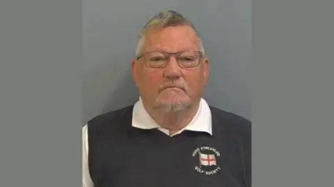 A police custody photo of Allen Morgan, wearing a white shirt and blue sweater vest