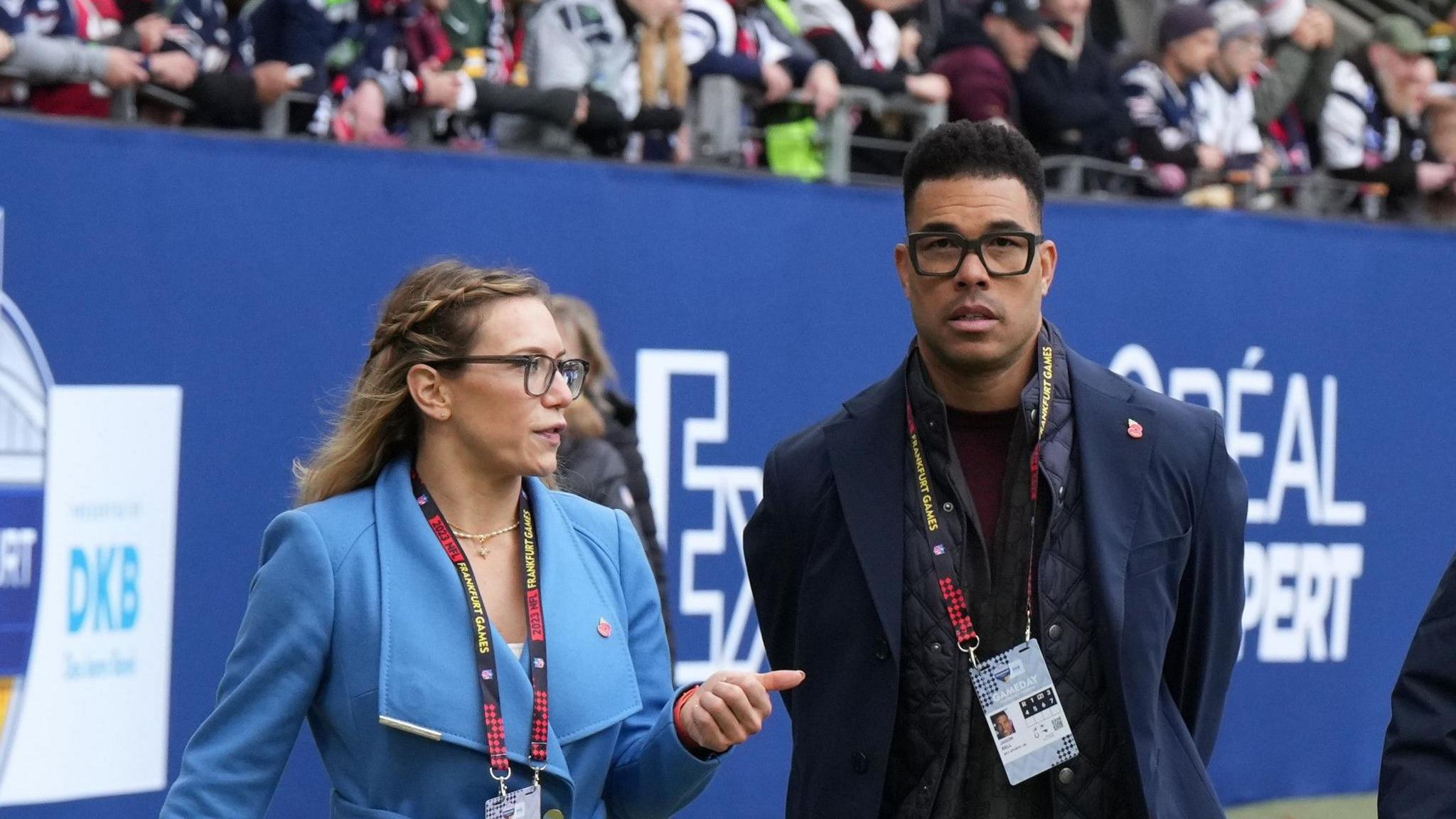 Phoebe Schecter with NFL analyst Jason Bell on the sidelines of an NFL match