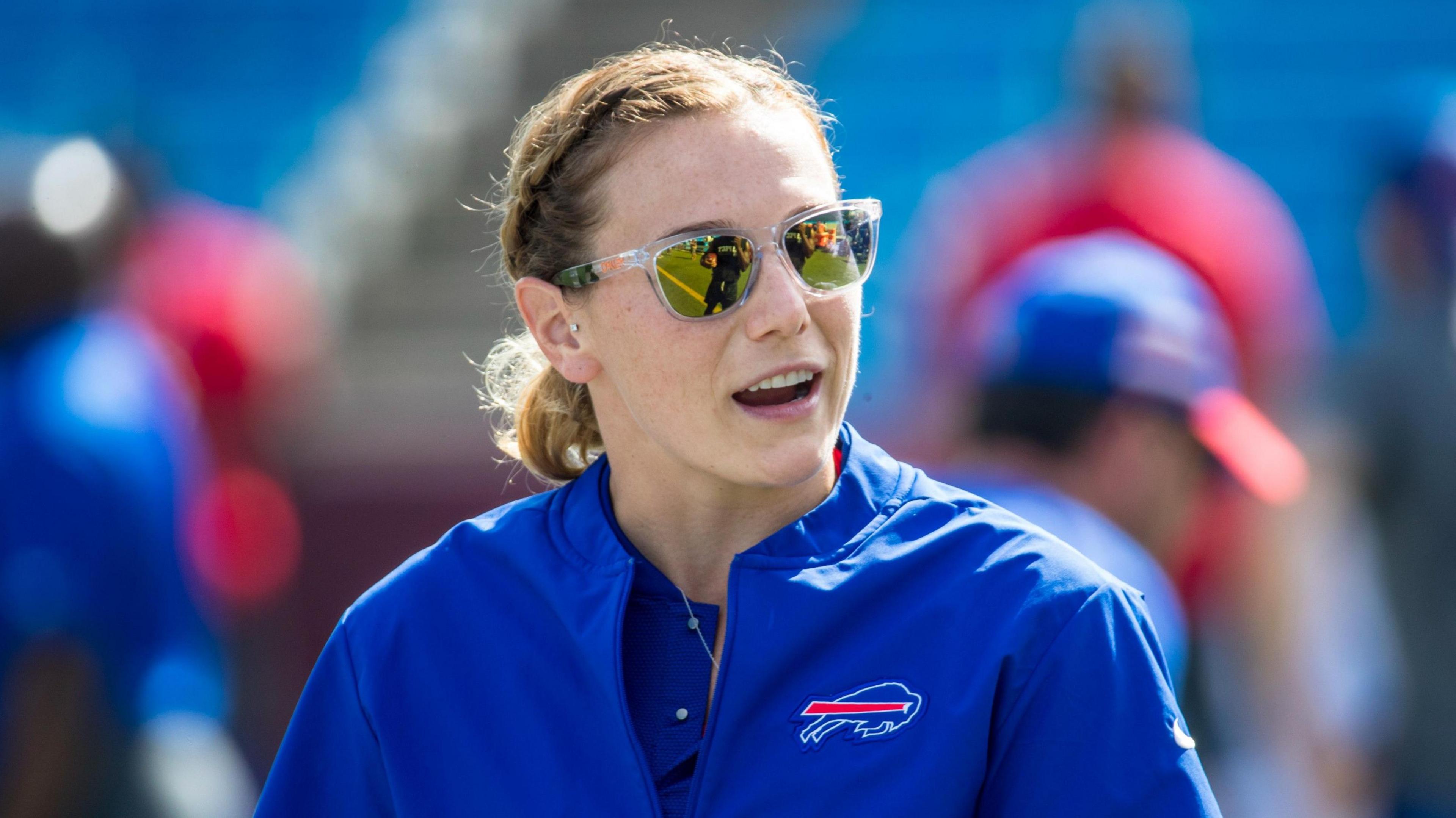 Phoebe Schecter wearing sunglasses and a blue Buffalo Bills jacket