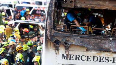 Thai forensic police officers inspect a burnt bus on Vibhavadi Rangsit road in Bangkok, Thailand, 01 October 2024.