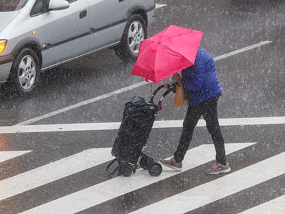 Un hombre se protege de la lluvia en Zaragoza a la vuelta de la compra el pasado 21 de septiembre.