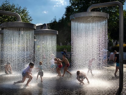 Unos niños se refrescan en fuentes públicas en Vilna (Lituania), el domingo, en plena ola de calor que va de Argelia a Escandinavia pasando por Italia, Grecia, los Balcanes y centro Europa.