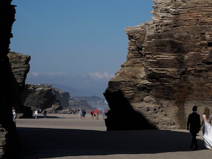 Una pareja de novios aprovecha este miércoles para hacerse el reportaje de boda en la playa de Las Catedrales en Ribadeo (Lugo), aprovechando la marea viva.