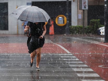 Una mujer camina por un paso de peatones bajo una intensa lluvia el pasado día 2 en Valencia.