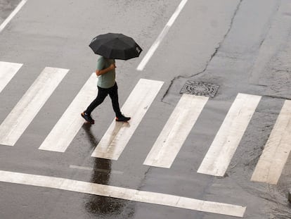 Un hombre se protege de la lluvia a primera hora del pasado miércoles en Teruel.