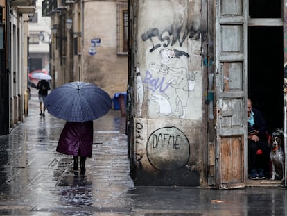 Una persona camina bajo la lluvia por las calles del centro histórico de Valencia, el  jueves.