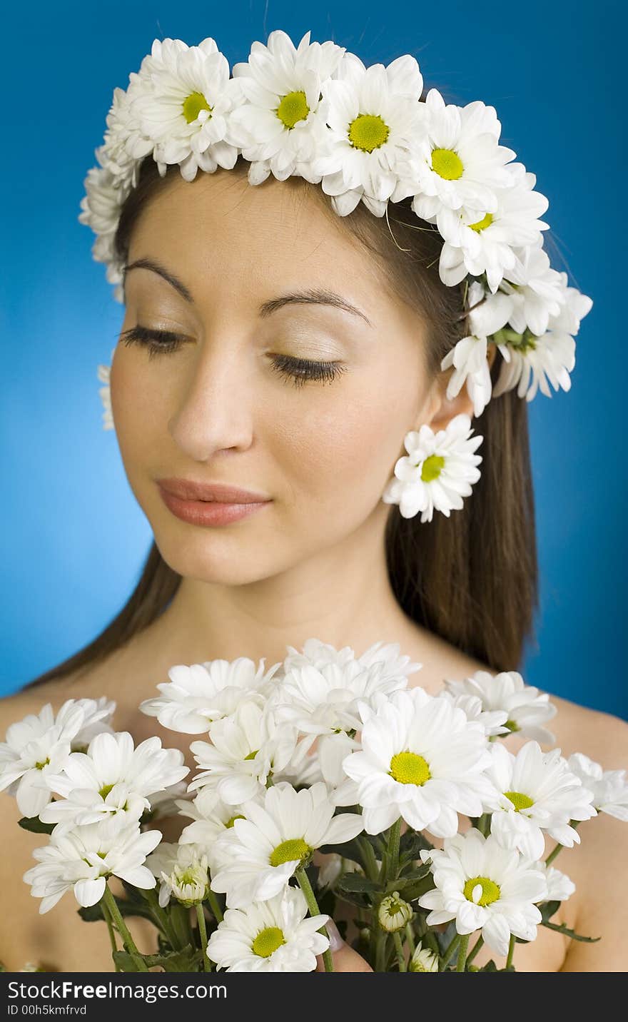 Young, beautiful and modest woman with bouquet of white flowers. Blue background. Young, beautiful and modest woman with bouquet of white flowers. Blue background