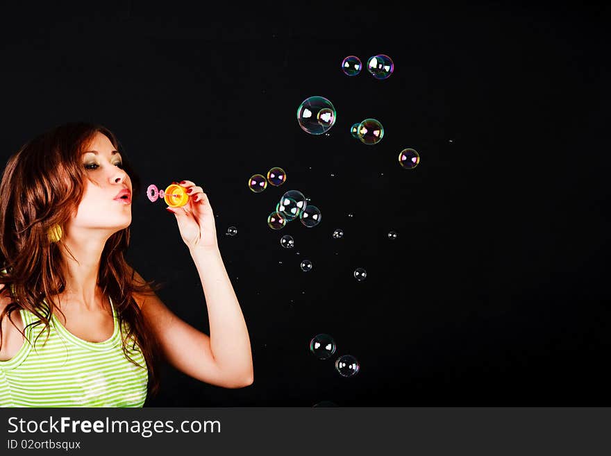 Picture of a young modest beautiful girl lets soap balls on back background