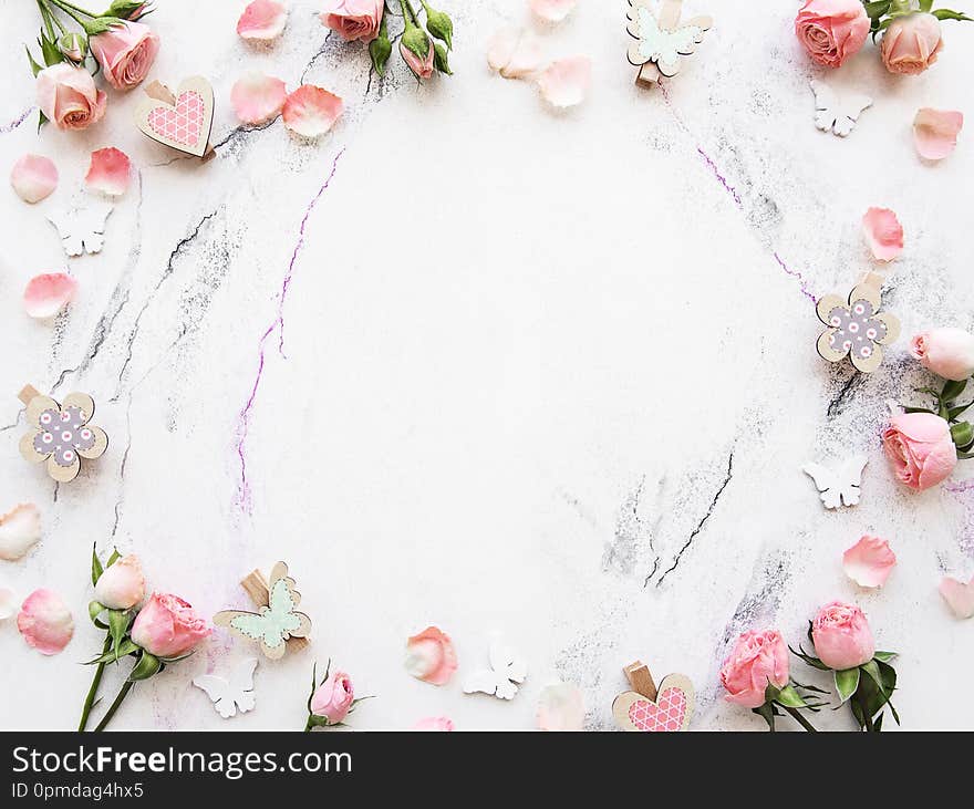 Spring holiday theme, pink roses and  decorations  on a white marble background