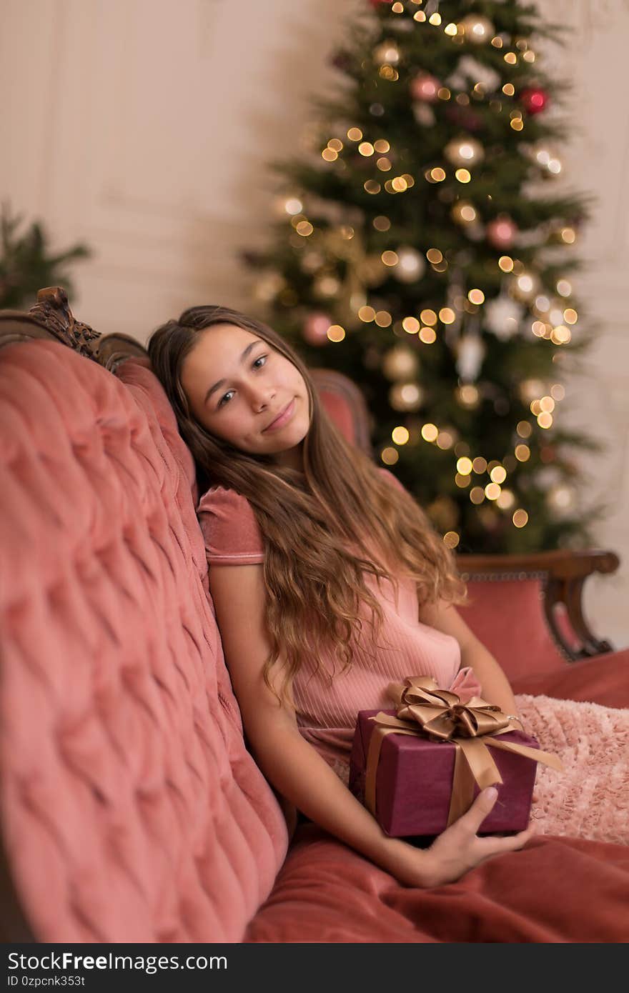 Gorgeous girl with a holiday christmas present in a stylish interior.