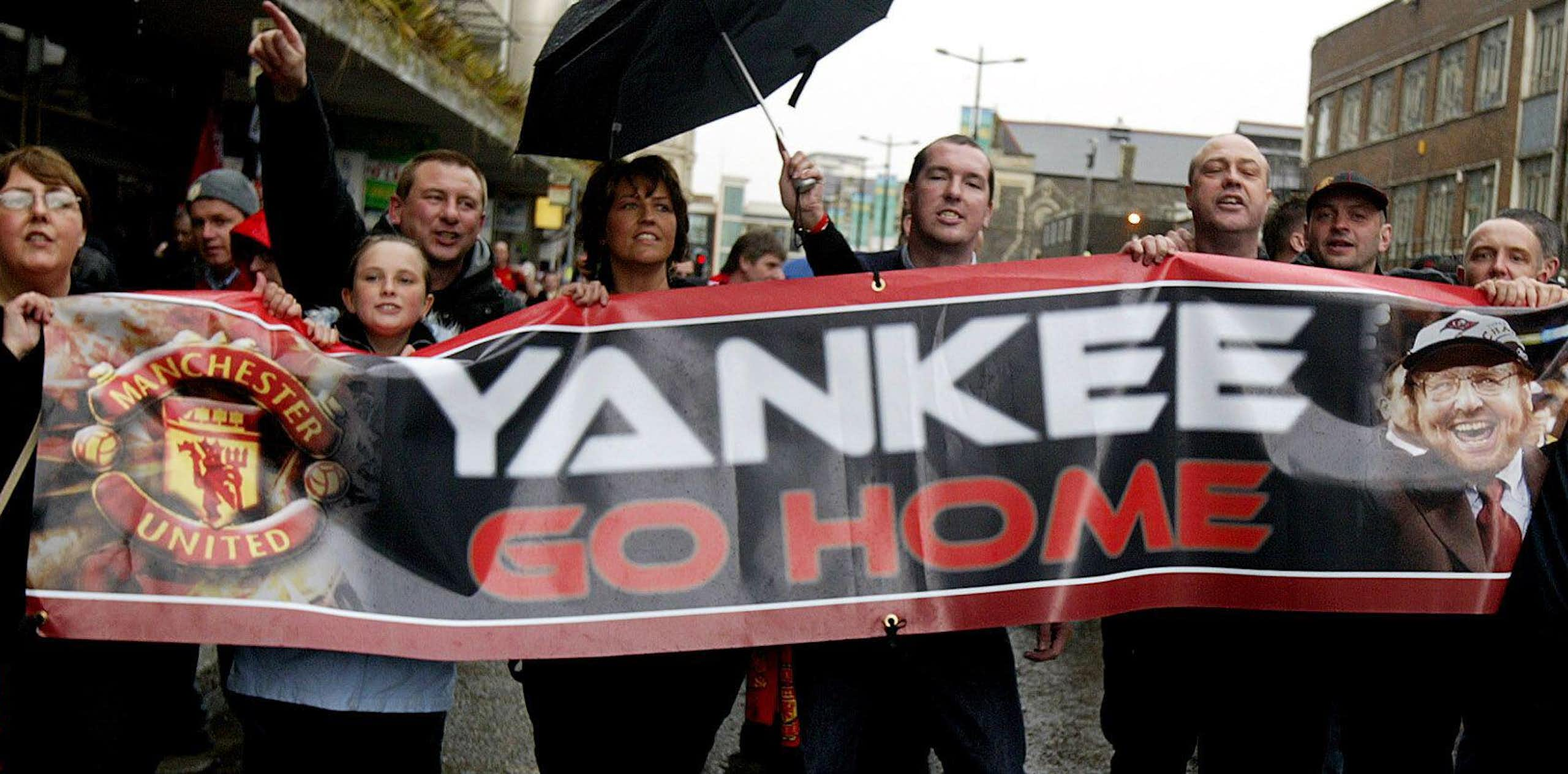 Manchester United fans holding a banner telling new American owner Malcolm Glazer to 'go home'.