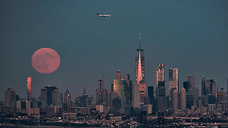 A strawberry moon rising over the Manhattan skyline.