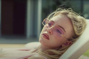 Sydney Sweeney lounges poolside, wearing stylish pink rectangular sunglasses and a relaxed expression. Background includes a modern building