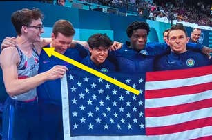 Six Team USA male gymnasts, including individual gold medalist, hold an American flag and smile after winning the team gold medal at a competition
