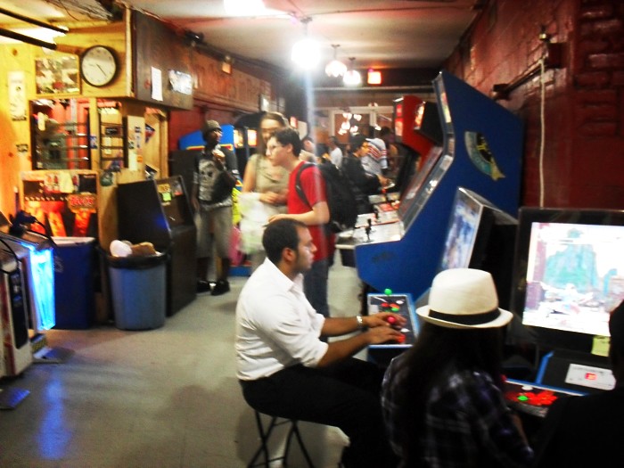 A photograph of the Chinatown fair, pre-renovation. Lots of people huddled around arcade machines.