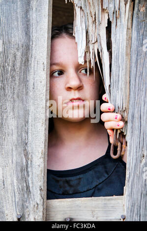 Girl looking out of barn Stock Photo