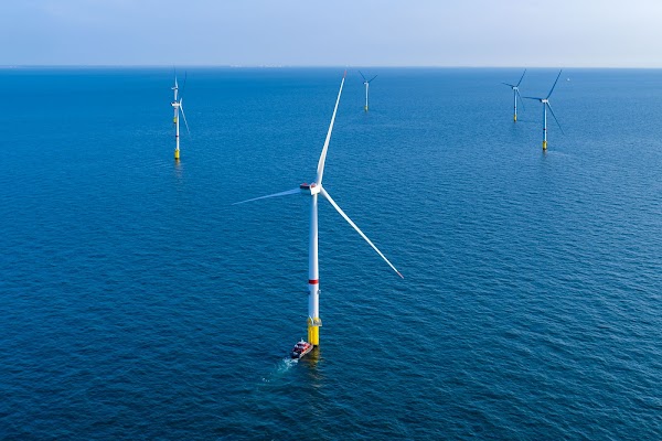 Seis molinos de viento en el océano bajo un cielo azul