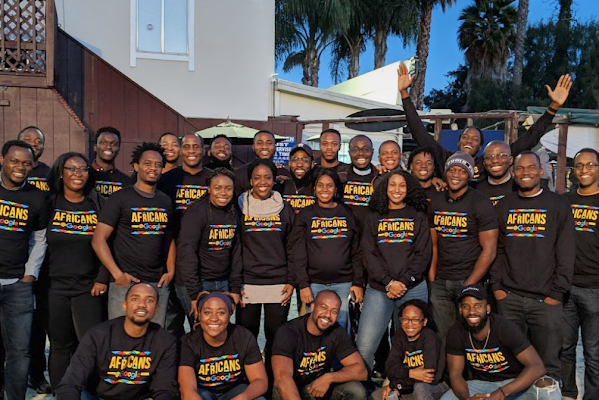 Group of smiling Googlers wearing Black@Google sweatshirts