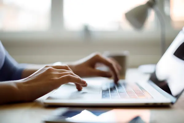 Close up of someone using their laptop while working from home