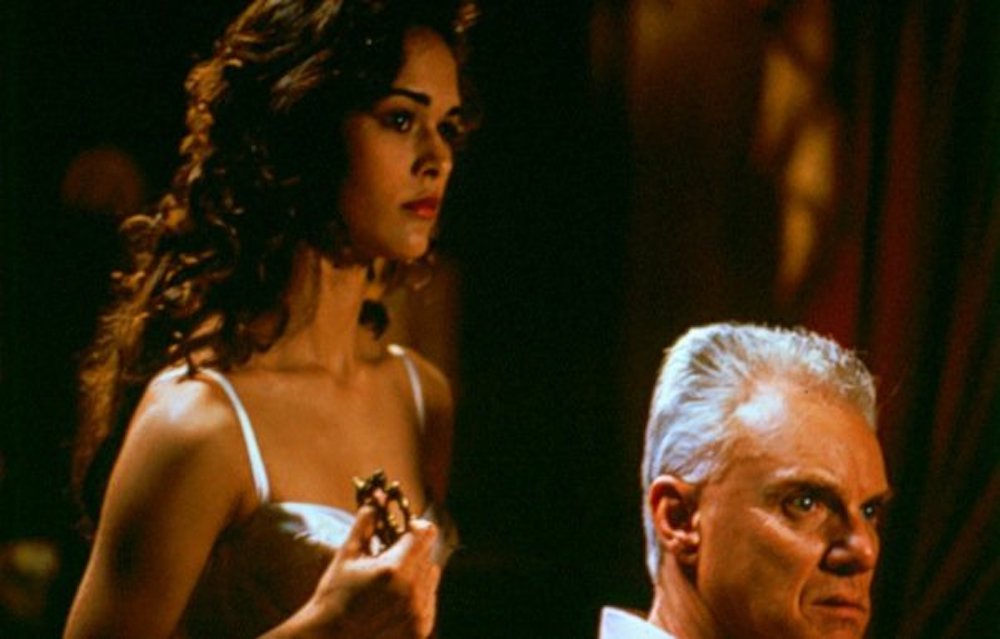 Malcolm McDowell and Sydney Penny in In the Eye of the Snake (1990)