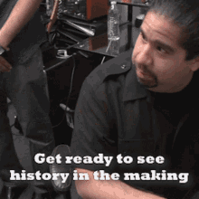 a man sitting in front of a desk with the words get ready to see history in the making on the bottom