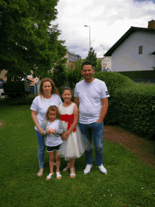 a family poses for a picture in a grassy area