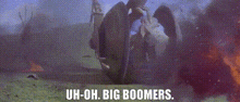 a man is standing in front of a large object with the words `` uh-oh , big boomers '' written on it .